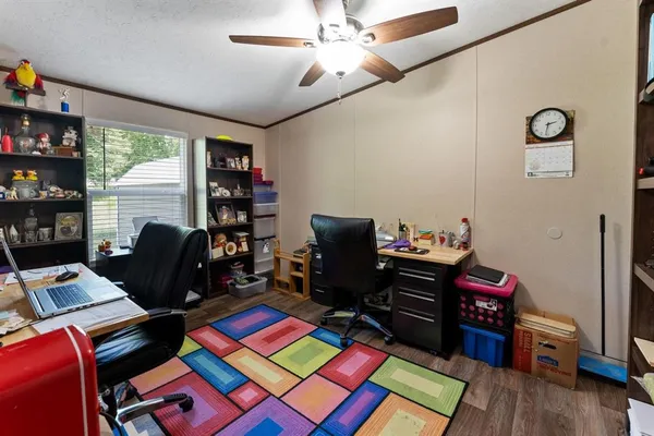 a view of a workspace with furniture and a book shelf