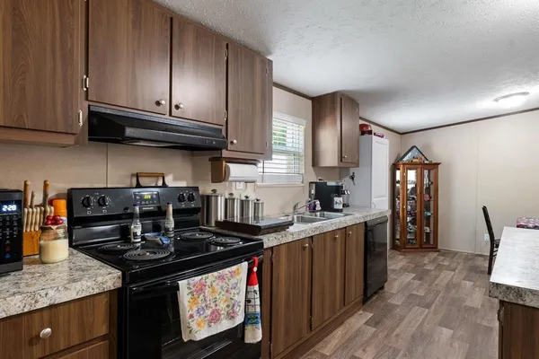 a kitchen with granite countertop a stove top oven sink and cabinets