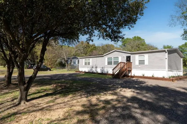 a view of a house with backyard and trees