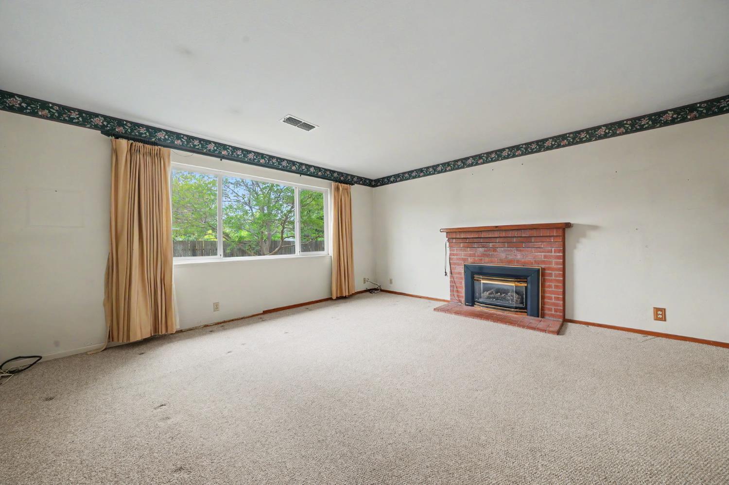 626 Sutter Lane Ione, CA 95640 - Photo 10 of 21 a view of an empty room with a fireplace and a window