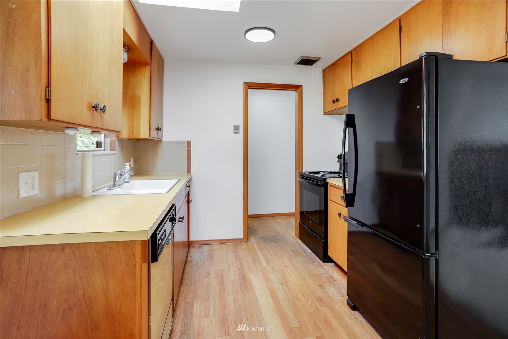 454 Lind Avenue Northwest Renton, WA 98057 - Photo 7 of 35 a kitchen with a refrigerator and a sink