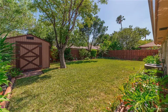 a view of a backyard with wooden fence and large trees