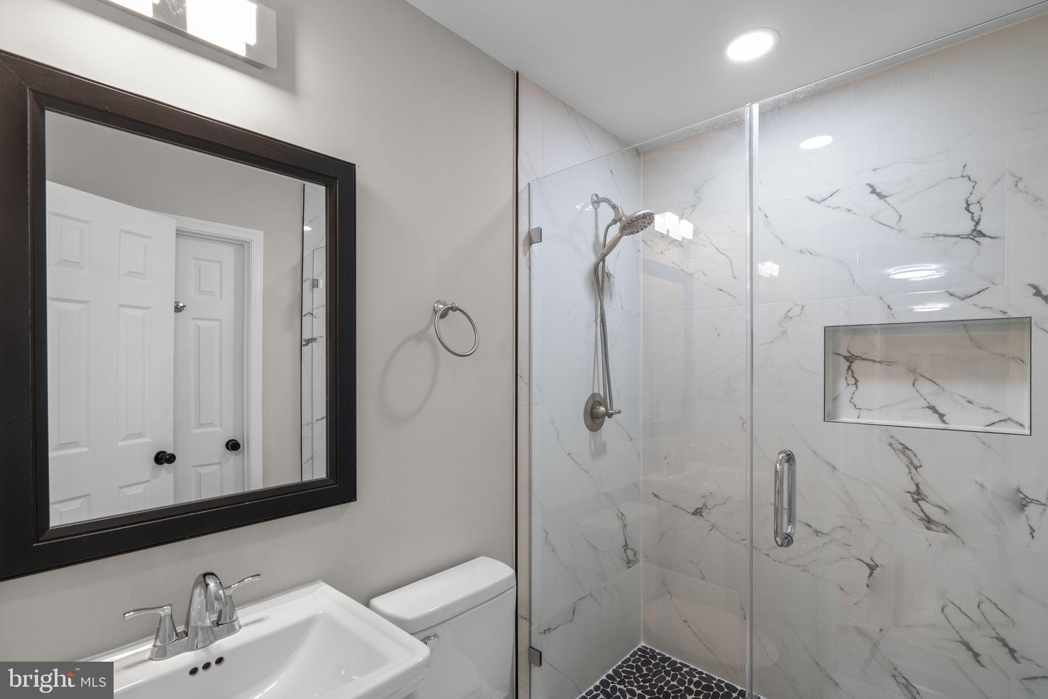 1501 Pine Grove Road Capitol Heights, MD 20743 - Photo 27 of 44 a bathroom with a shower a sink and mirror