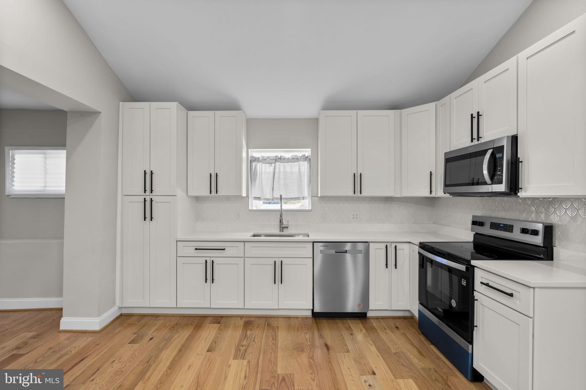 1501 Pine Grove Road Capitol Heights, MD 20743 - Photo 5 of 44 a kitchen with stainless steel appliances a sink cabinets and wooden floor