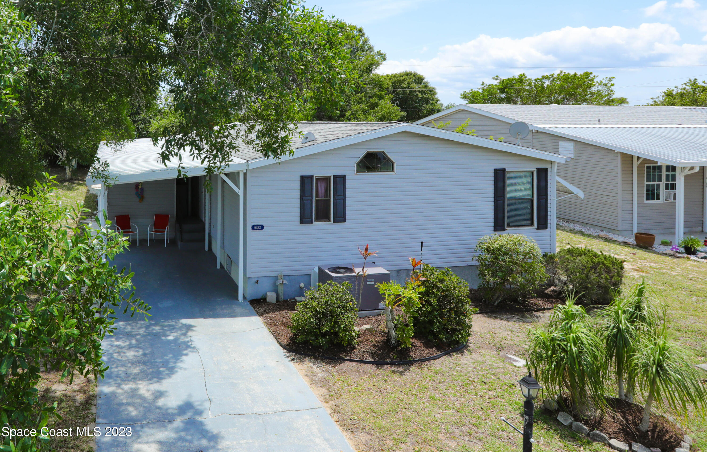 a view of a house with a yard and potted plants