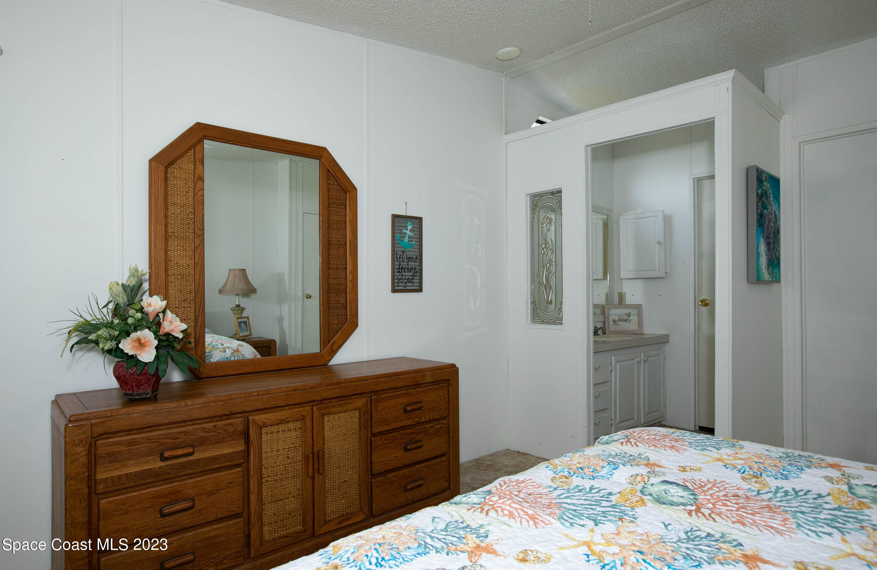 6183 97th Street Sebastian, FL 32958 - Photo 11 of 18 a bedroom with a bed and a dresser in it