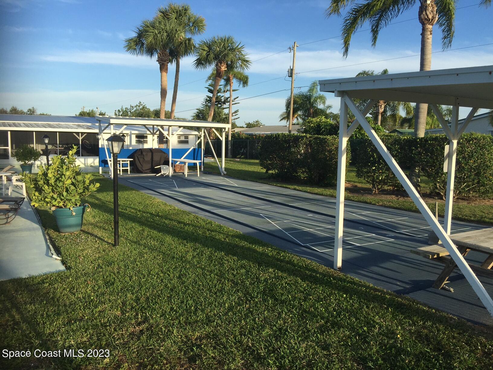 6183 97th Street Sebastian, FL 32958 - Photo 18 of 18 a view of a swimming pool with a table and chairs a fire pit