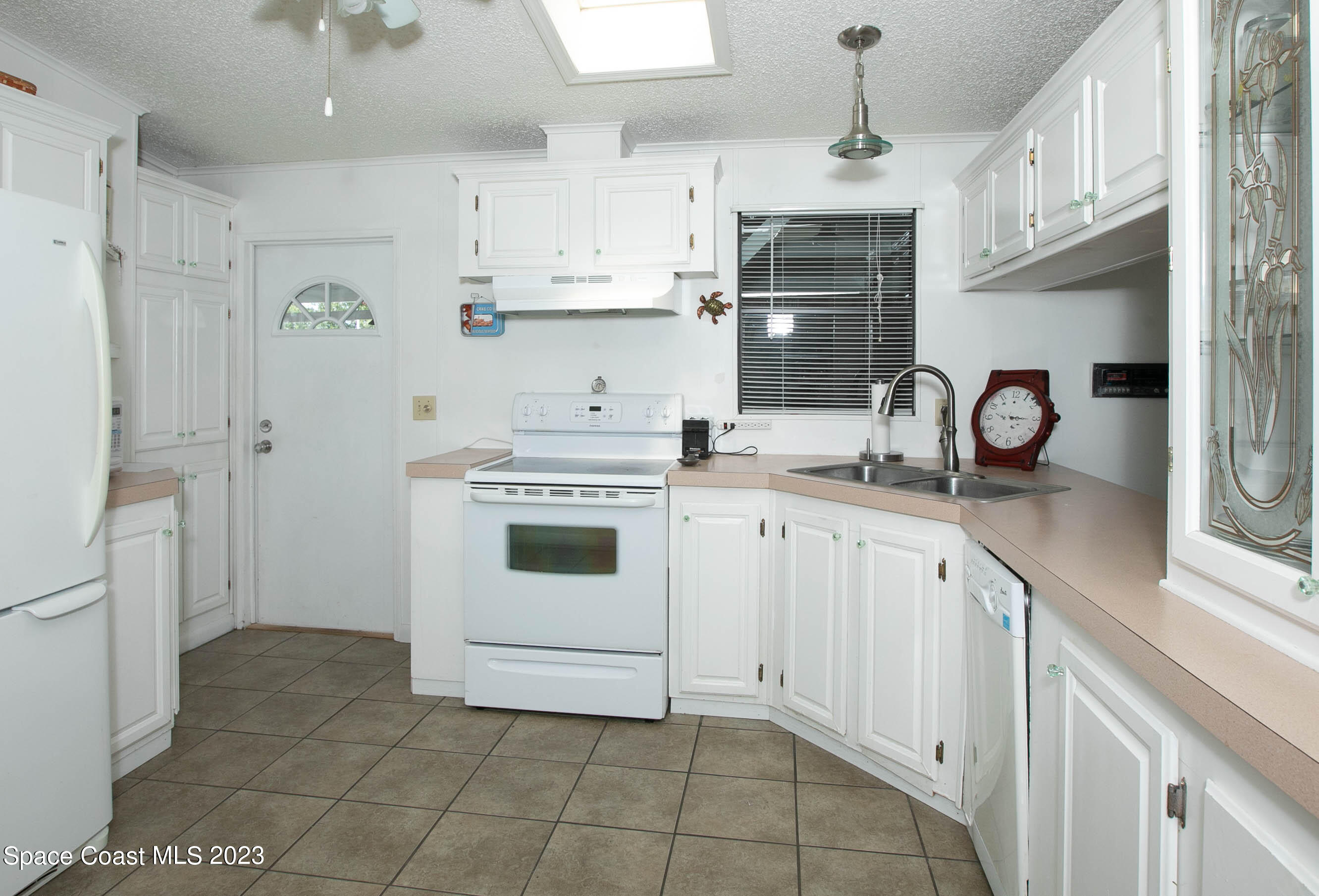 6183 97th Street Sebastian, FL 32958 - Photo 8 of 18 a kitchen with stainless steel appliances granite countertop a sink a stove a refrigerator and cabinets