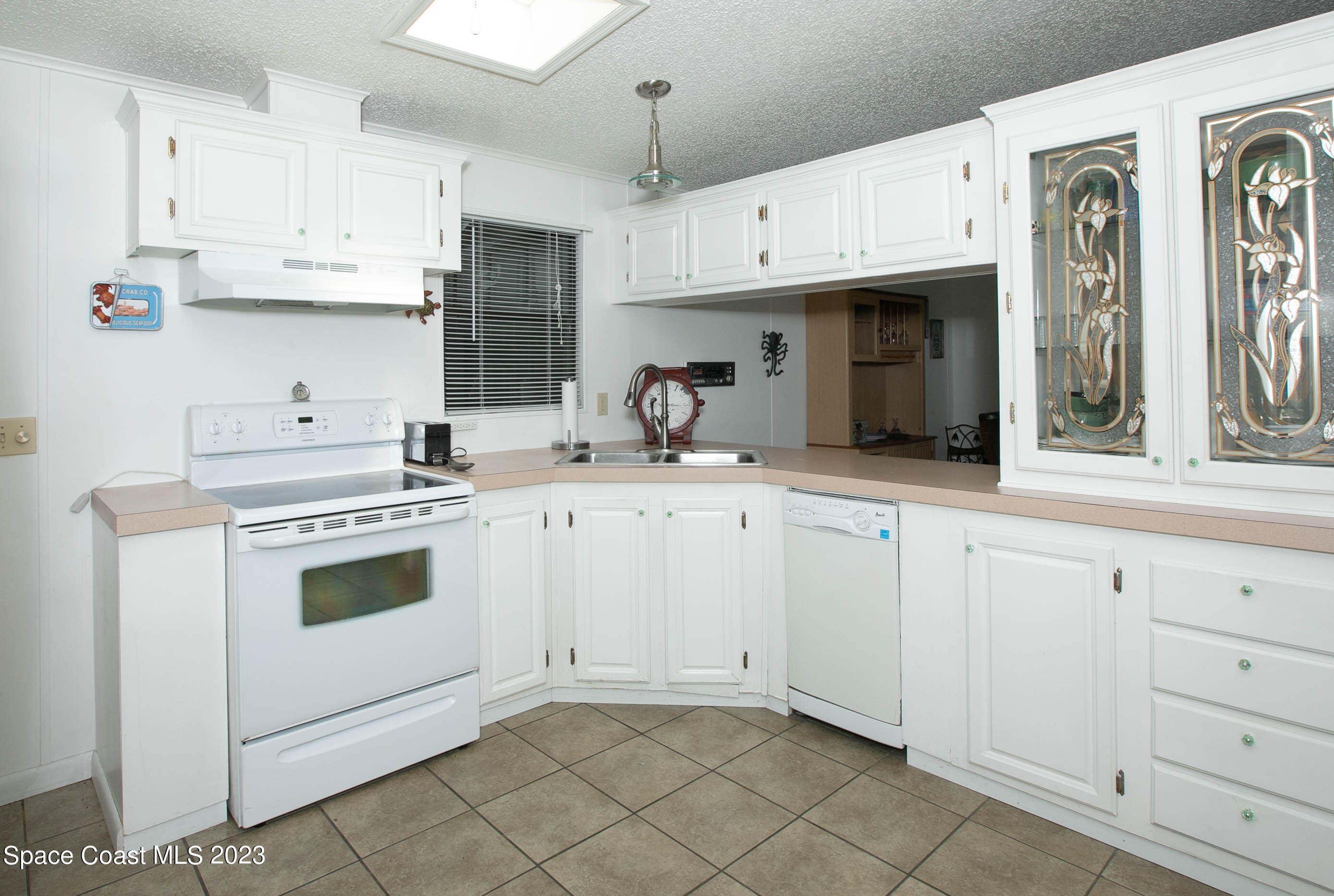6183 97th Street Sebastian, FL 32958 - Photo 9 of 18 a kitchen with granite countertop white cabinets and white appliances