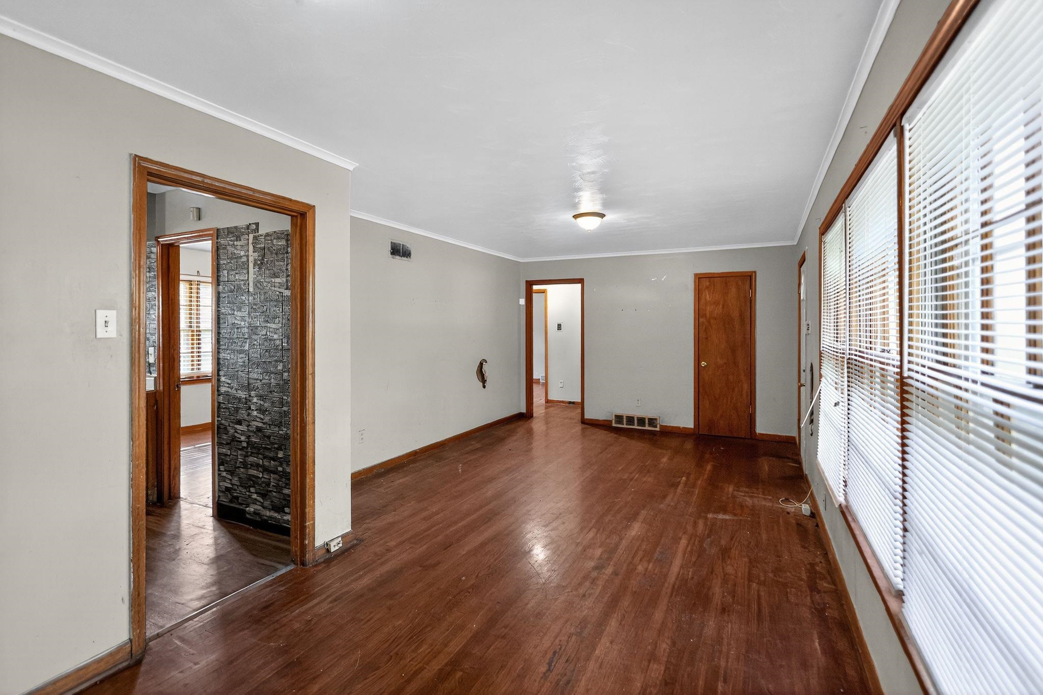 4905 Lochinvar Road Memphis, TN 38116 - Photo 5 of 33 an empty room with wooden floor and windows