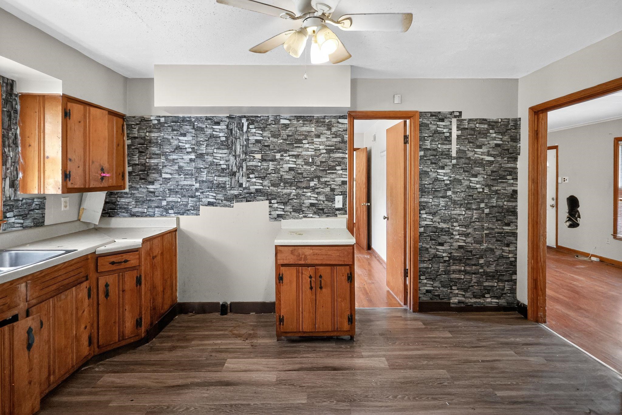 4905 Lochinvar Road Memphis, TN 38116 - Photo 6 of 33 a kitchen with stainless steel appliances granite countertop a refrigerator a sink dishwasher and wooden cabinets with wooden floor