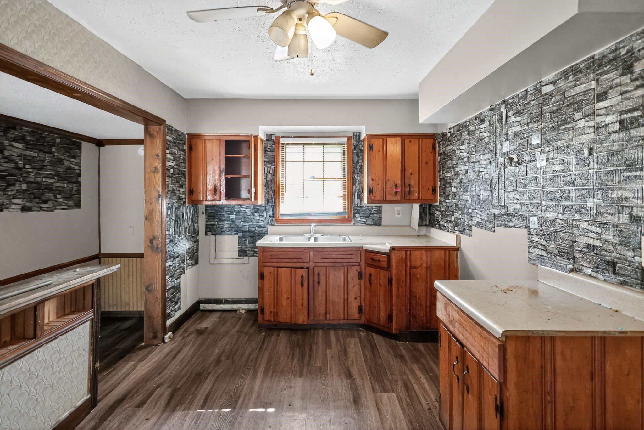 4905 Lochinvar Road Memphis, TN 38116 - Photo 7 of 33 a kitchen with sink cabinets and wooden floor