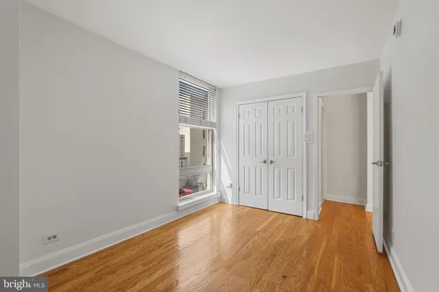 a view of empty room with wooden floor