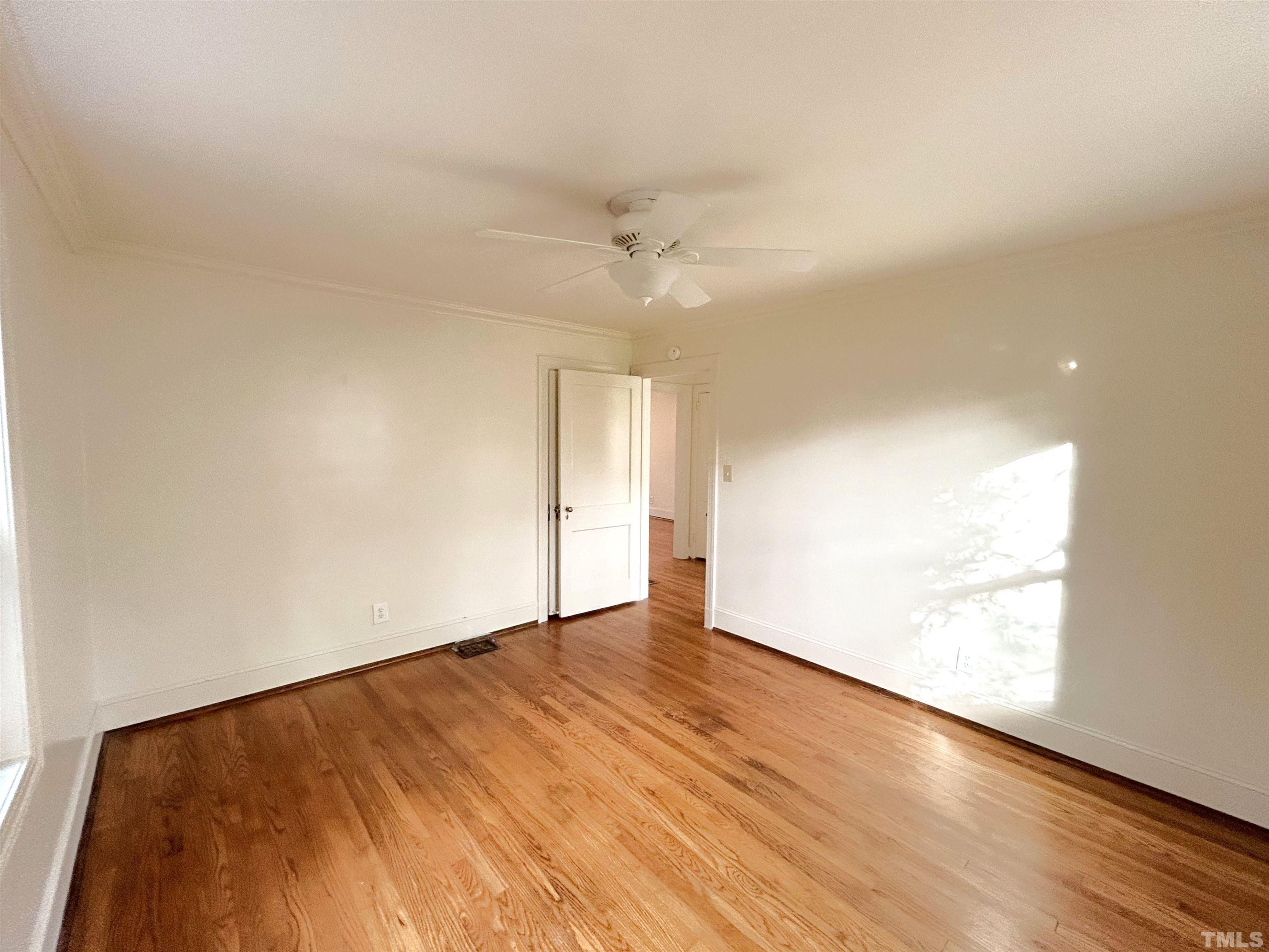 1607 Carson Street Raleigh, NC 27608 - Photo 14 of 17 an empty room with wooden floor ceiling fan and windows