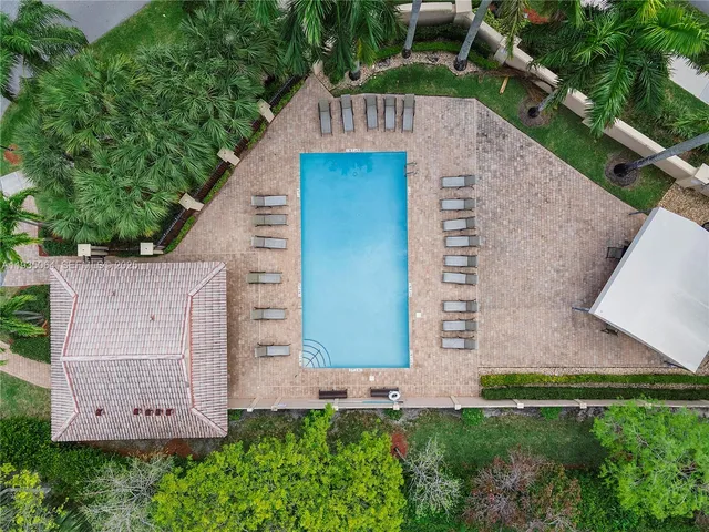 an aerial view of residential houses with outdoor space and trees