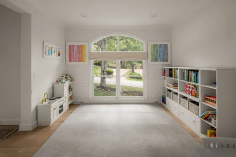 an empty room with bookshelf and a window