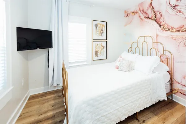 a bedroom with a bed and a flat screen tv