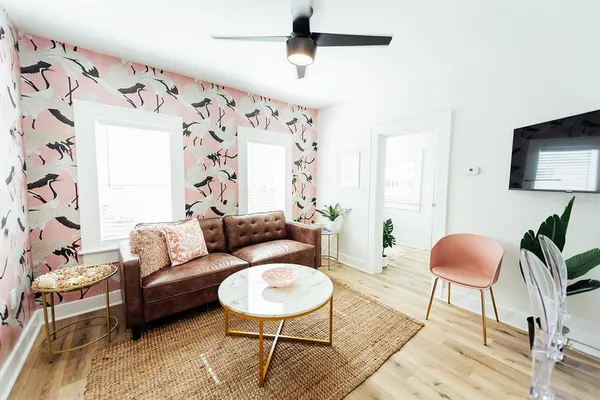 a living room with furniture flowerpot and wooden floor