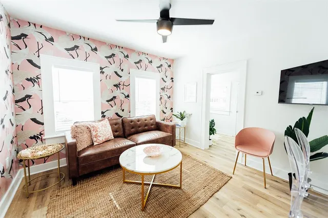 a living room with furniture flowerpot and wooden floor