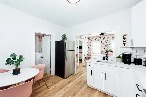 a kitchen with a sink and a stove with wooden floor