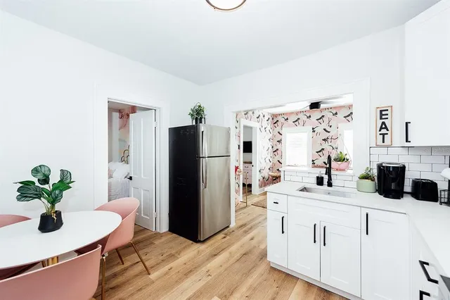 a kitchen with a sink and a stove with wooden floor
