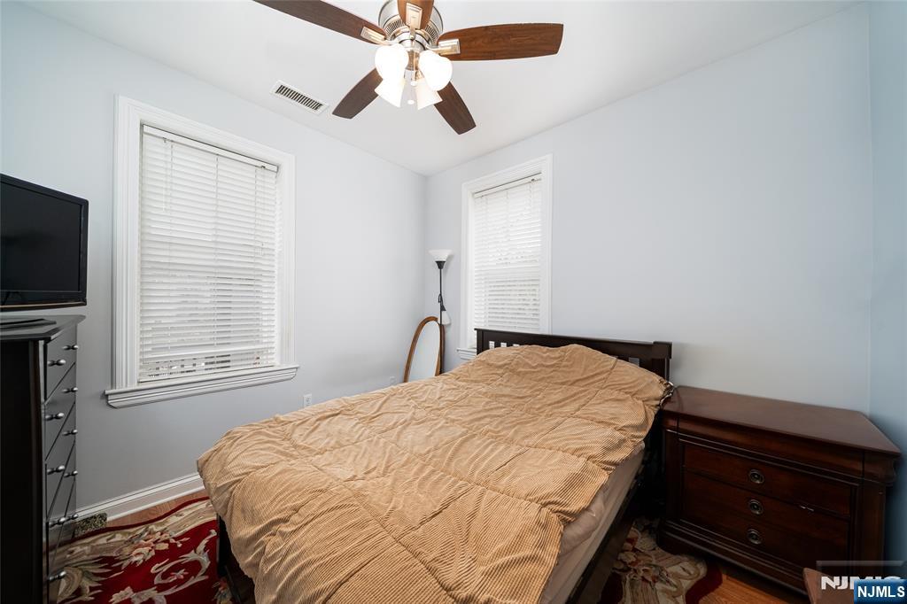 26 Orange Road Montclair, NJ 07042 - Photo 30 of 45 a bedroom with a bed and a flat tv screen on dresser