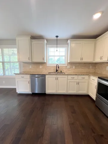 a kitchen with granite countertop cabinets sink and window