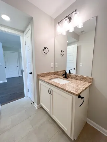 a bathroom with a granite countertop sink a toilet and shower