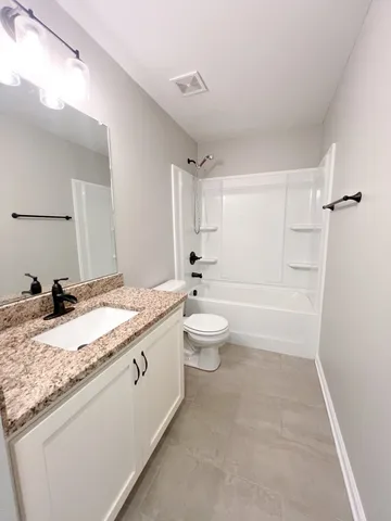 a white toilet sitting next to a bath tub