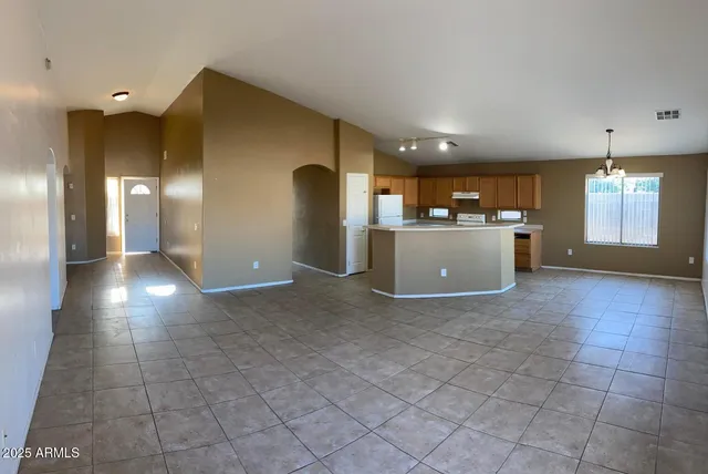a view of a livingroom with kitchen and a window