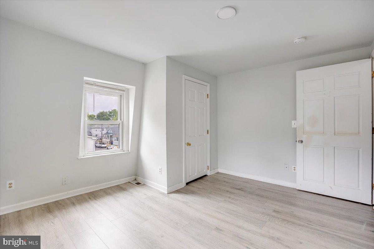 301 Broad Street Beverly, NJ 08010 - Photo 11 of 29 an empty room with wooden floor and windows