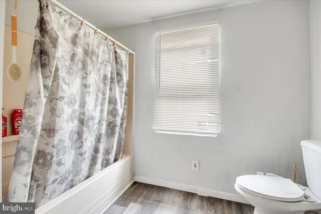 a bathroom with a toilet and a shower curtain