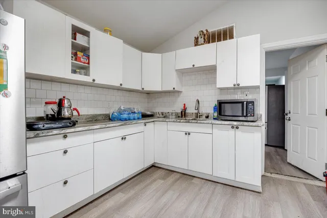 a kitchen with granite countertop white cabinets and white appliances