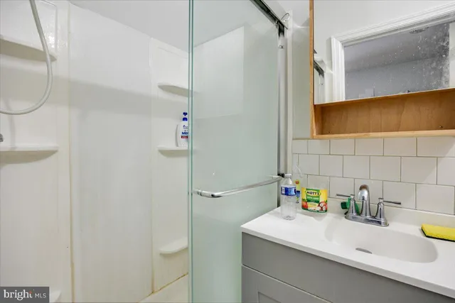 a bathroom with a sink a mirror and a shower