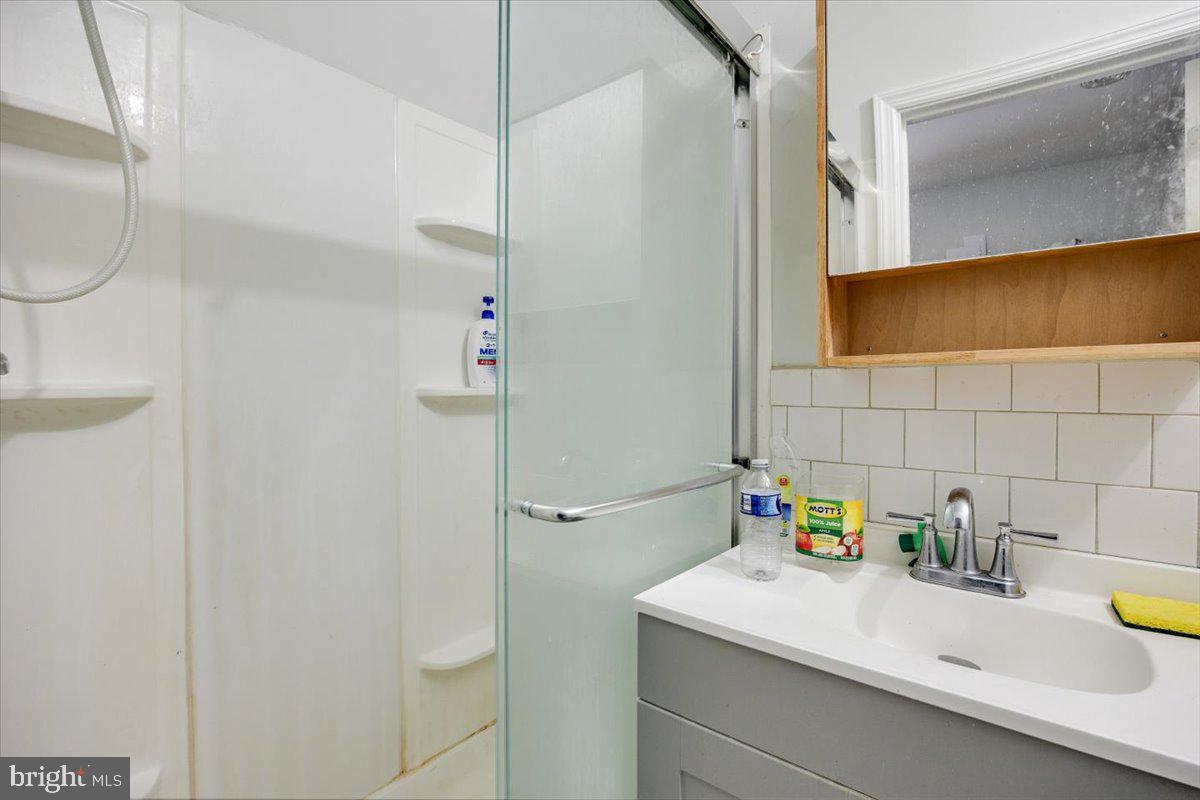 301 Broad Street Beverly, NJ 08010 - Photo 4 of 29 a bathroom with a sink a mirror and a shower