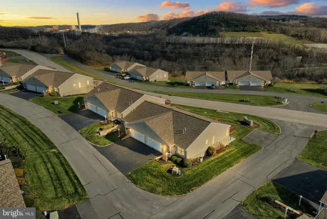 an aerial view of a house with a garden and lake view