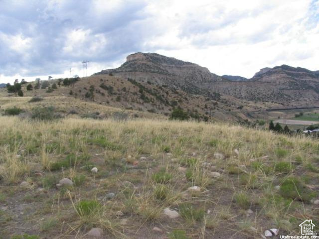 700 Spring Canyon Road Helper, UT 84526 - Photo 1 of 19 Expansive land parcel featuring natural grasses and scattered rocks, set against a backdrop of rugged mountains