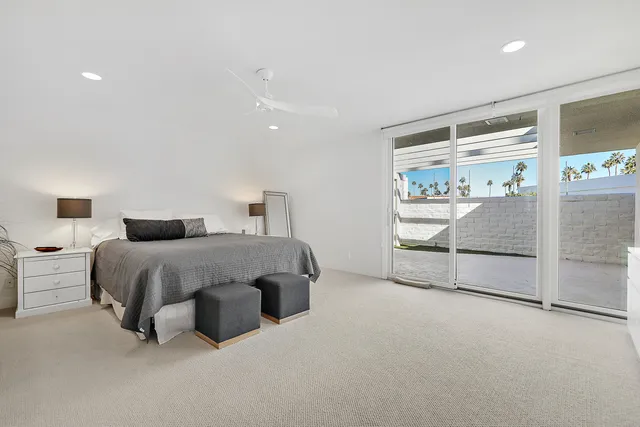 a spacious bedroom with a bed and a large window