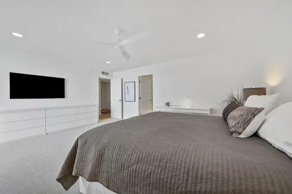 a spacious bedroom with a bed and a flat screen tv