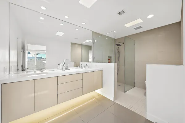a bathroom with a double vanity sink a mirror and a shower