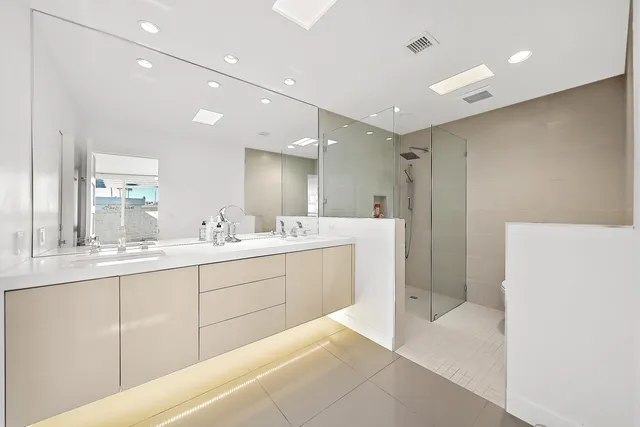 a bathroom with a double vanity sink a mirror and a shower