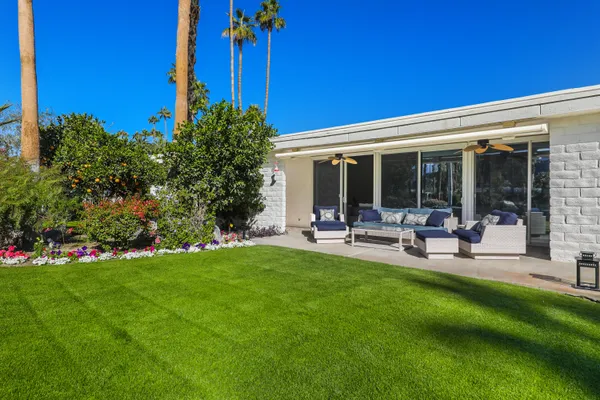 a view of a house with backyard sitting area and garden