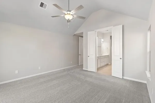 an empty room with chandelier fan and windows