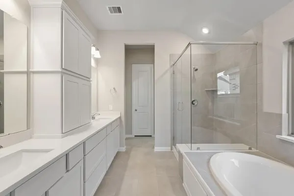 a spacious bathroom with a bathtub shower sink vanity and mirror