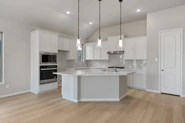 a kitchen with kitchen island a sink stainless steel appliances and cabinets