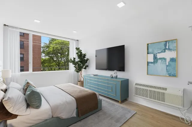 a bedroom with a bed and a flat screen tv