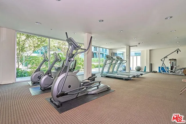 a room with gym equipment and large windows