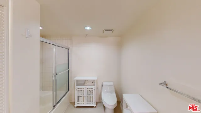 a bathroom with a shower a toilet and a sink