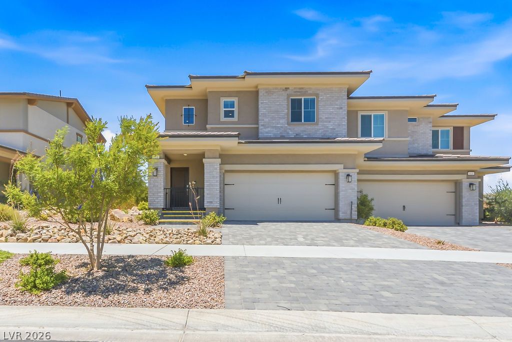 913 Cadence View Way Henderson, NV 89011 - Photo 6 of 46 A modern facade with layered architecture and a paver driveway creates compelling curb appeal.