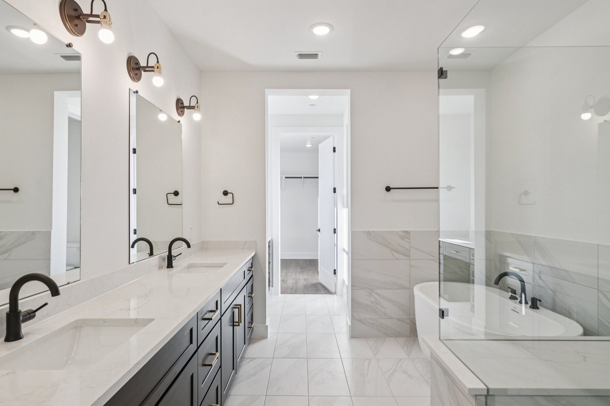4311 Prevail Lane Austin, TX 78731 - Photo 16 of 40 a bathroom with a double vanity sink a mirror and a bathtub